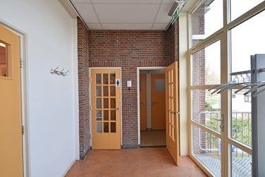 <p>In schoon metselwerk uitgevoerde scheidingswand tussen de gang en de aanbouw met de toiletten op de verdieping. De deuren dateren nog uit de bouwtijd. </p>
